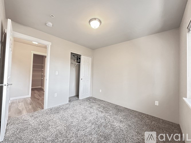 A room with a carpeted floor and a doorway leading to another room.