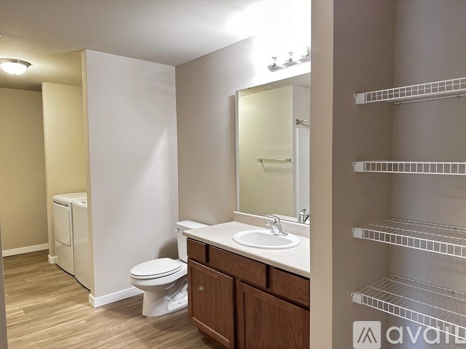A bathroom with a toilet, sink, and mirror.