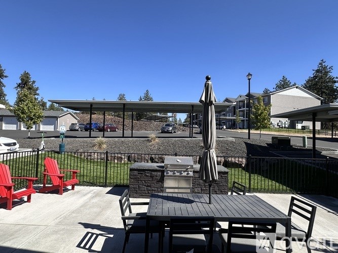 A patio with a table, chairs, and an umbrella.
