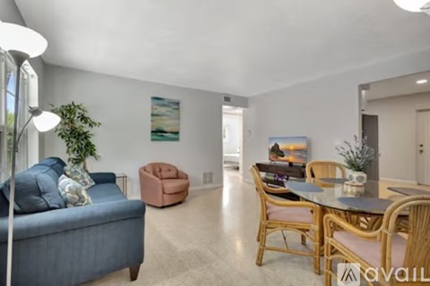 A living room with a blue couch and a brown chair.