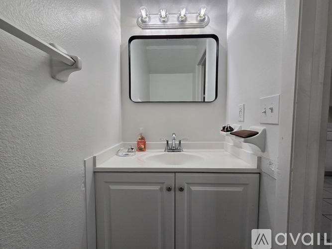 A bathroom with a white sink and a mirror above it.