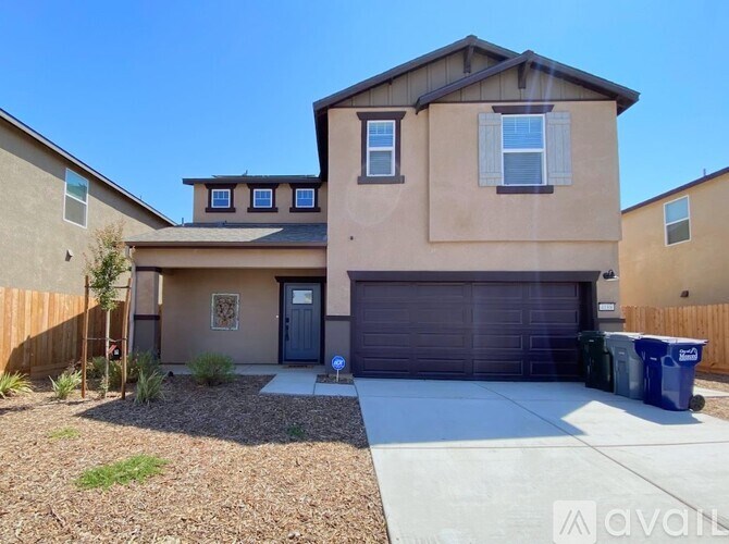 A beige house with a blue door and garage door.