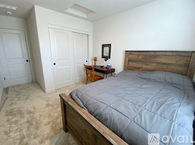 A bedroom with a bed, nightstand, and two doors.