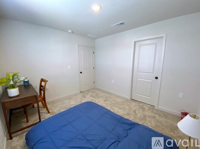 A room with a bed, a desk, and a chair.