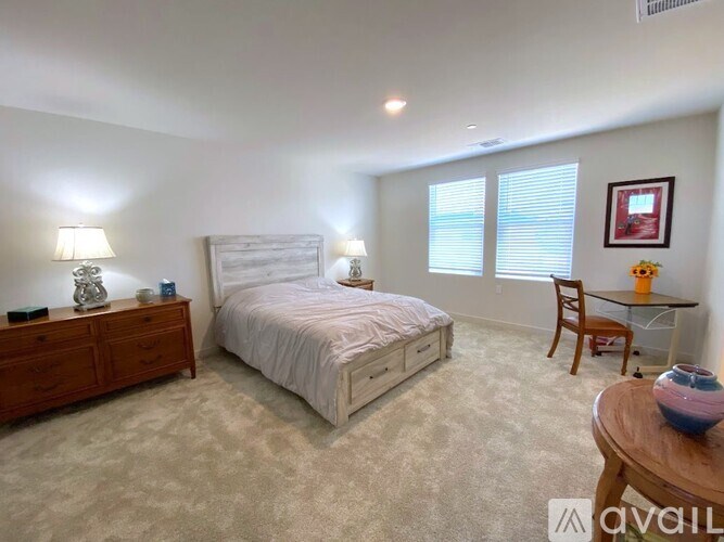 A bedroom with a bed, nightstand, and chair.