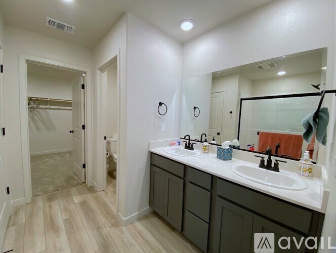 A bathroom with a double sink vanity and a walk-in shower.