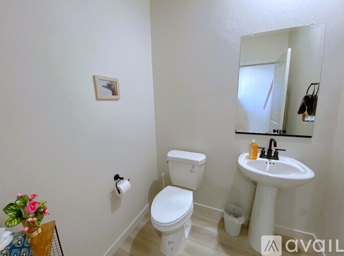 A white toilet and sink in a small bathroom.