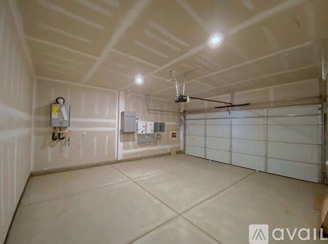 A spacious garage with a ceiling fan and a white door.
