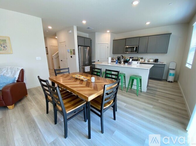 A kitchen with a dining table and chairs in the foreground.