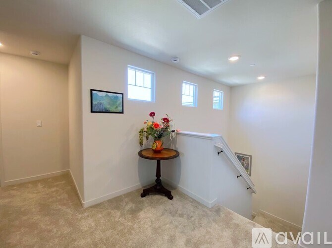 A room with a table holding flowers and a painting on the wall.