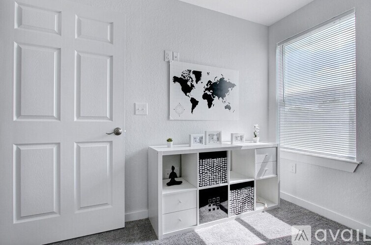A white room with a world map on the wall and a desk with drawers.
