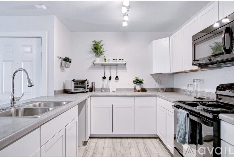 A kitchen with white cabinets and a black stove top oven.