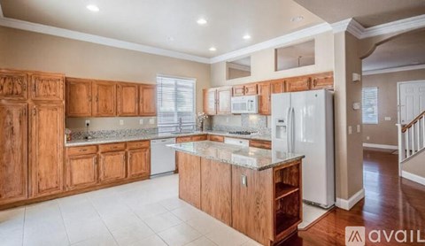 A kitchen with wooden cabinets and a marble countertop.