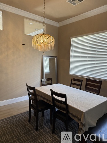 A spacious room with wooden floors and a staircase on the right side.