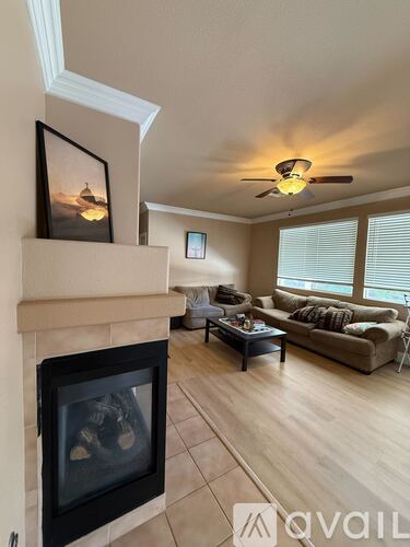 A room with a fan, carpet, and a window.