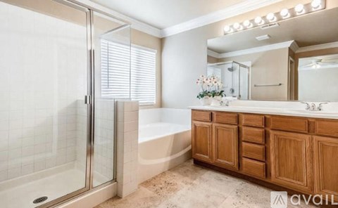 A bathroom with a tub, sink, and mirror.