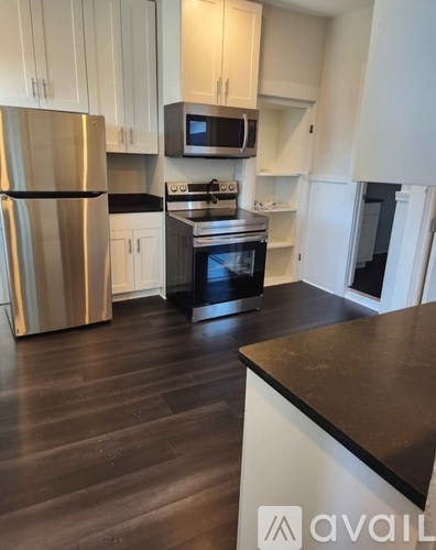 A kitchen with a stainless steel refrigerator, microwave, and oven.