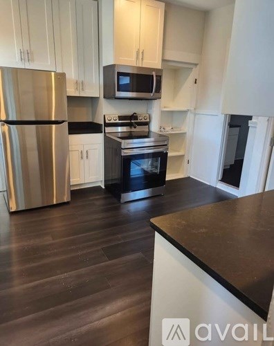 A kitchen with a stainless steel refrigerator, microwave, and oven.