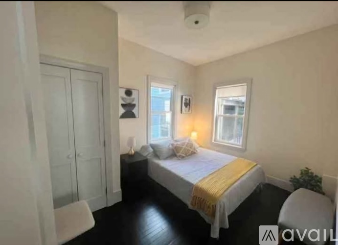 A bedroom with a bed, a chair, and a window.