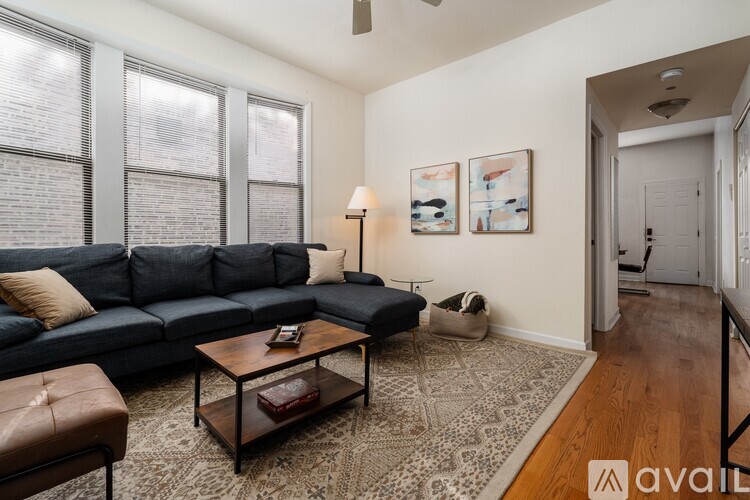 A living room with a blue couch, a coffee table, and a rug.