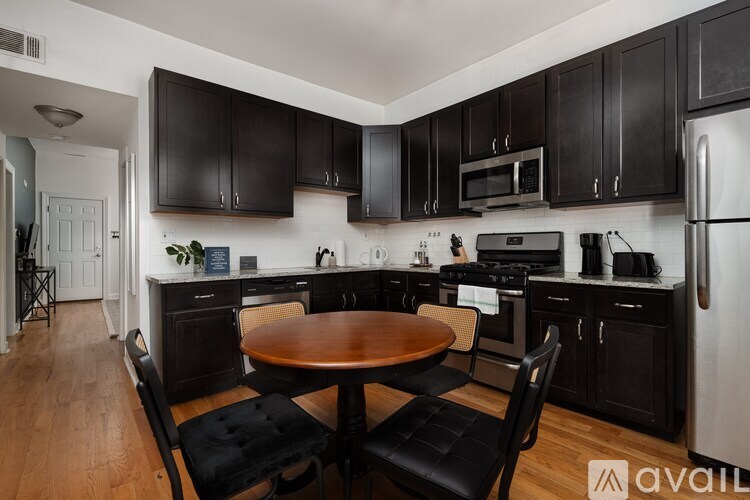 A kitchen with black cabinets and a wooden table.