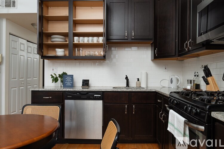 A kitchen with a stainless steel dishwasher and black oven.