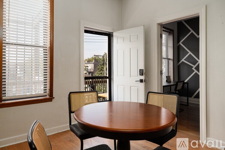 A dining room with a wooden table and chairs.