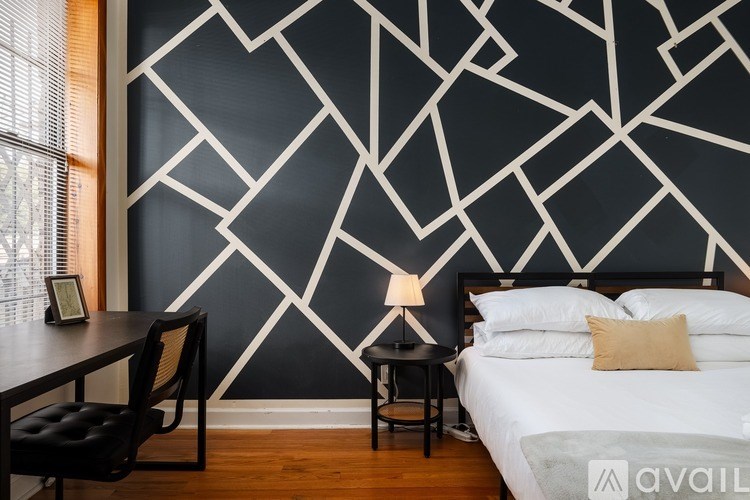 A bedroom with a black and white geometric wallpaper.