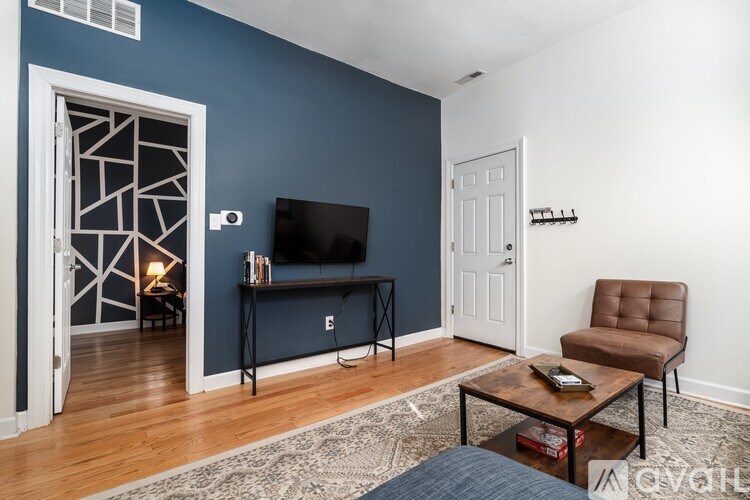 A living room with a brown leather chair and a flat screen TV.