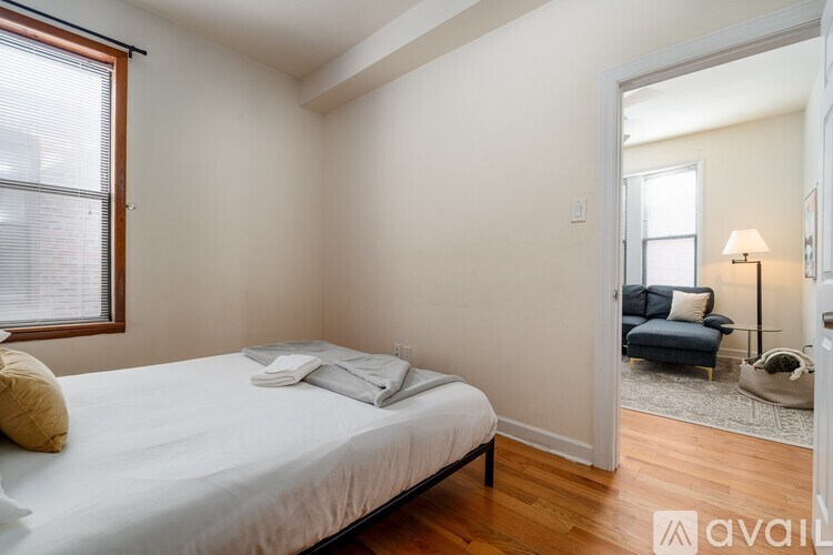 A bedroom with a bed, a window, and a lamp.