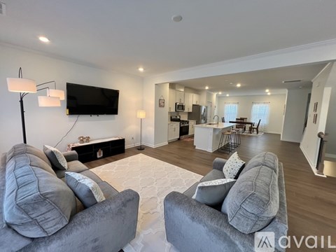 A modern living room with grey couches and a flat screen TV.