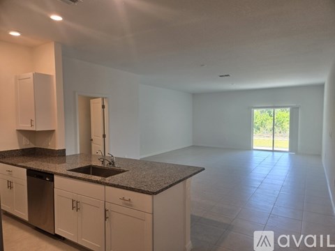 A kitchen with white cabinets and a granite countertop.