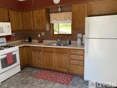 A kitchen with wooden cabinets and a white refrigerator.