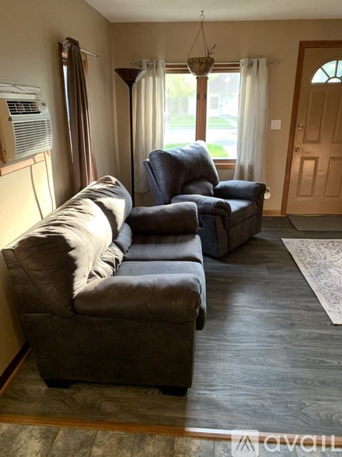 A living room with a grey couch and a black chair.