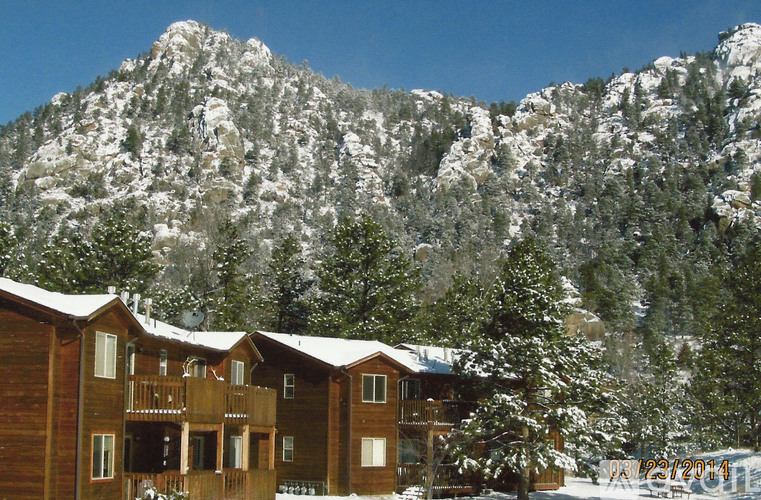 A mountain covered in snow with a building in front of it.