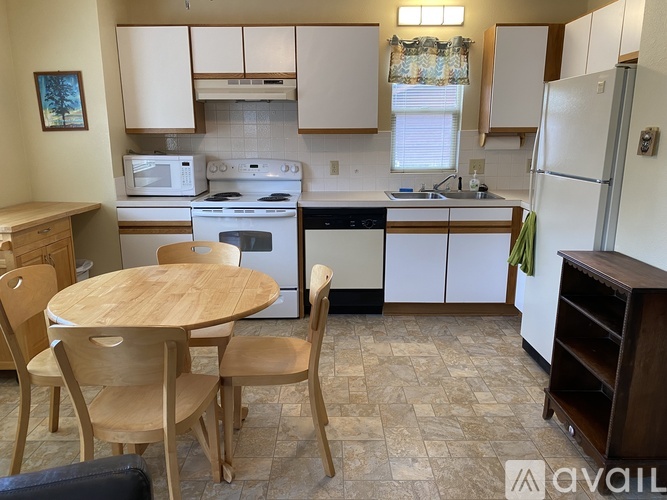 A kitchen with a table and chairs.