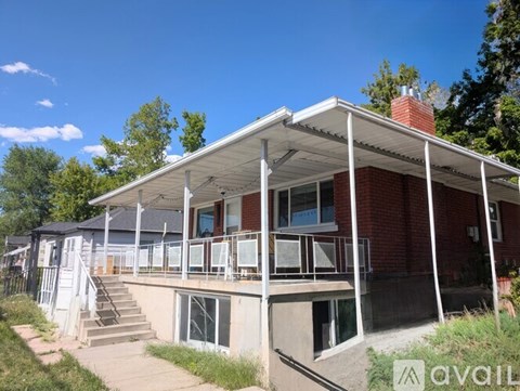 A house with a red brick exterior and a white roof is for sale.
