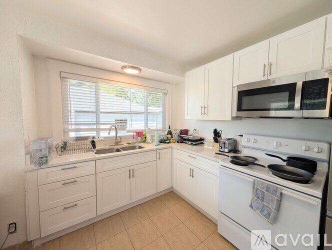 A kitchen with white cabinets and appliances.