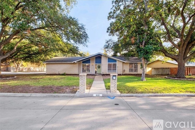 A house with a front yard and a tree in front of it.