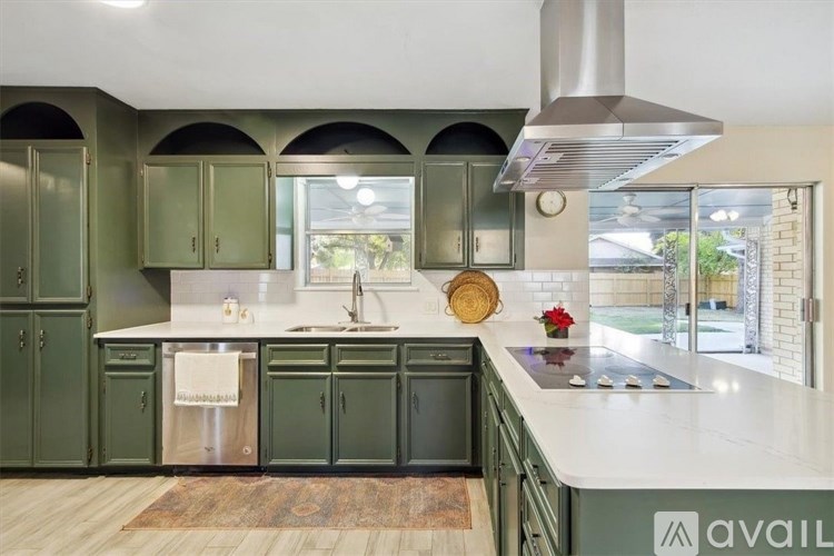 A kitchen with green cabinets and a white countertop.