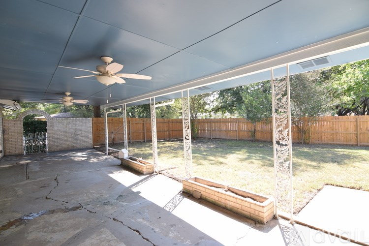 A room with a ceiling fan and wooden flooring.