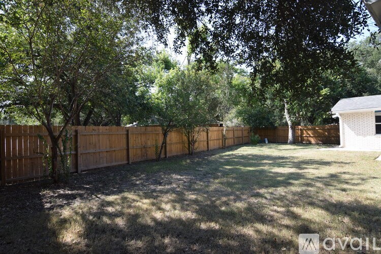 A kitchen with black cabinets and a window with curtains.
