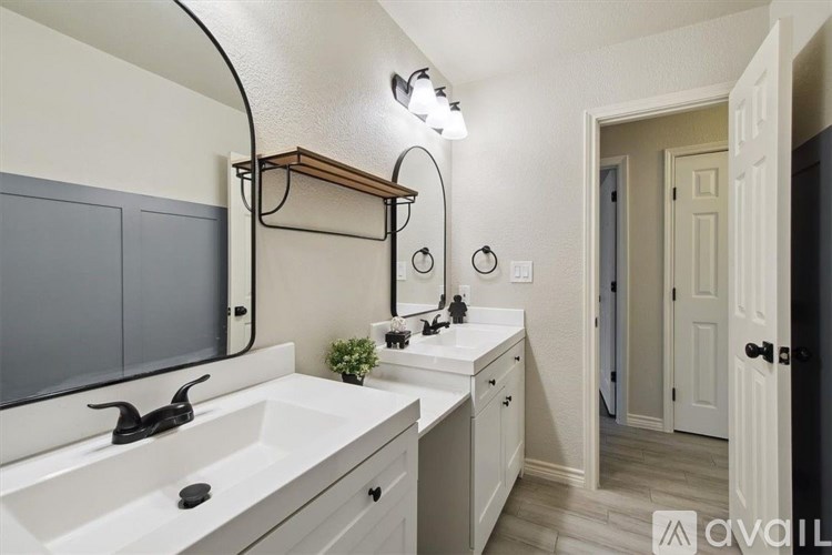 A bathroom with a white sink and a mirror with lights.