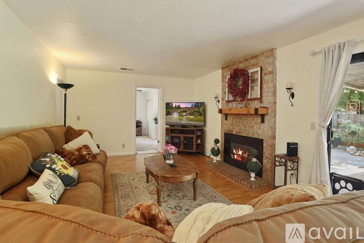 A living room with a couch, coffee table, and a fireplace.