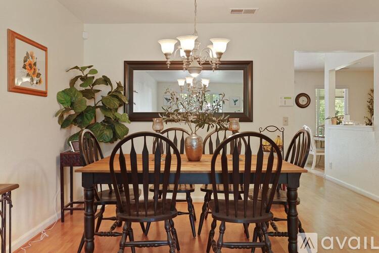 A dining room with a wooden table and chairs.