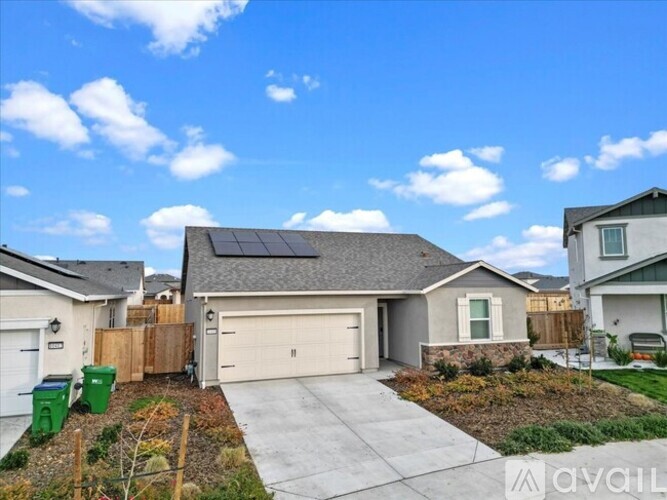 A house with a garage and solar panels on the roof.