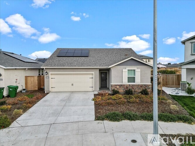 A house with a garage and solar panels on the roof.