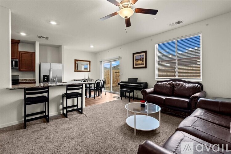 A living room with a brown leather couch and a white coffee table.