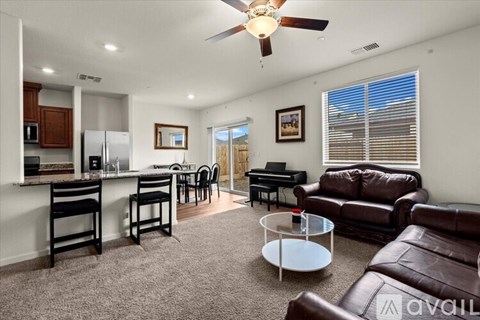 A living room with a brown leather couch and a white coffee table.