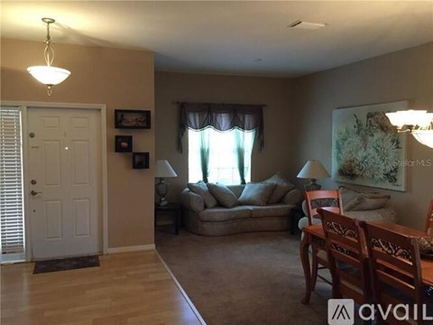 A living room with a couch, chairs, and a painting on the wall.